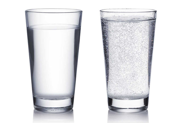Zwei Gläser nebeneinander, ein Glas mit Sprudel, eines ohne